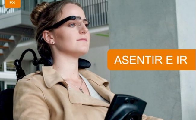 Una mujer sentada en una silla de ruedas tiene el control de movimiento de la silla mediante las gafas con el sistema munevo drive.